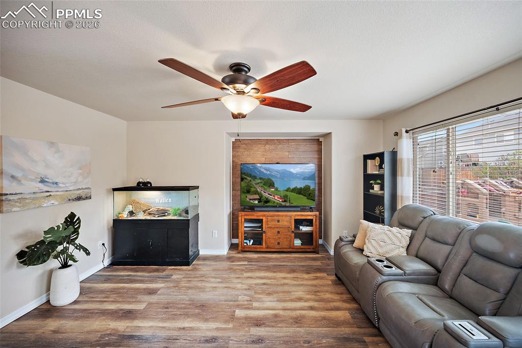 Image 10 of 43: Spacious living area featuring wood-finish flooring, a recessed entertainme