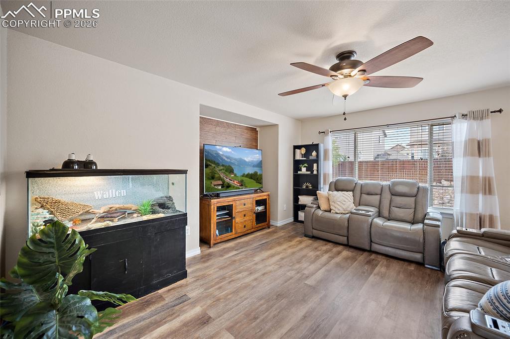 Image 12 of 43: Spacious interior featuring wood-finish flooring, a contemporary ceiling fa