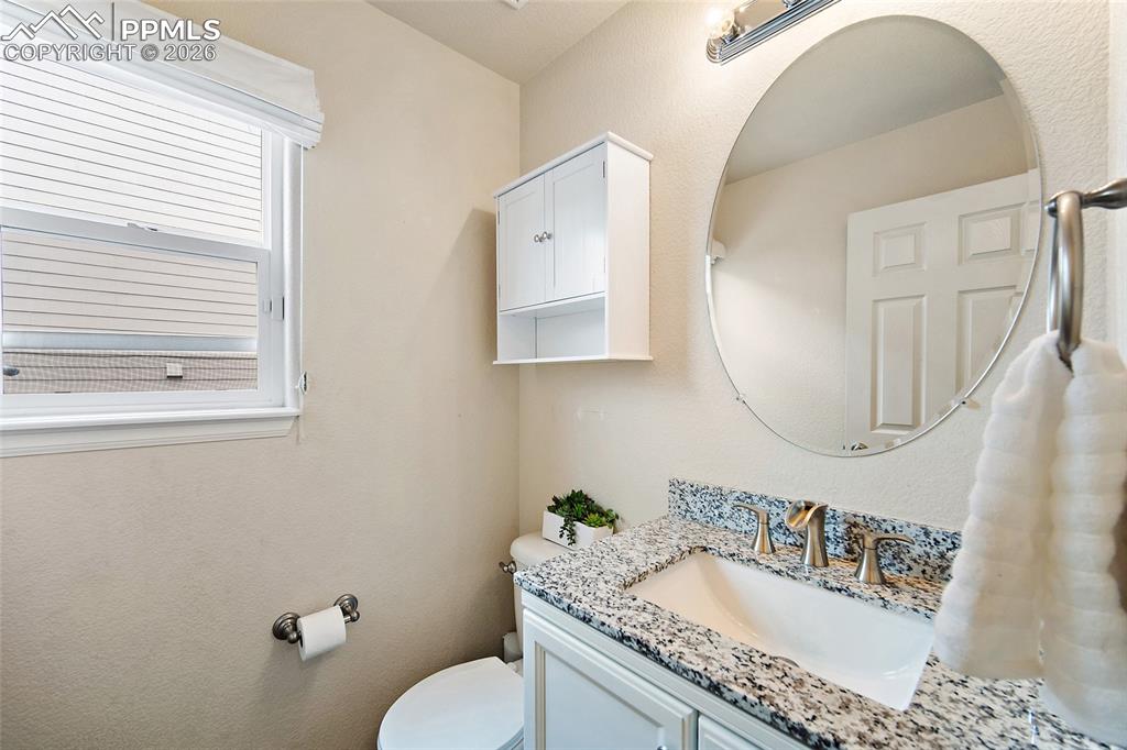 Image 13 of 43: Bathroom vanity featuring a granite countertop with an undermount sink and 