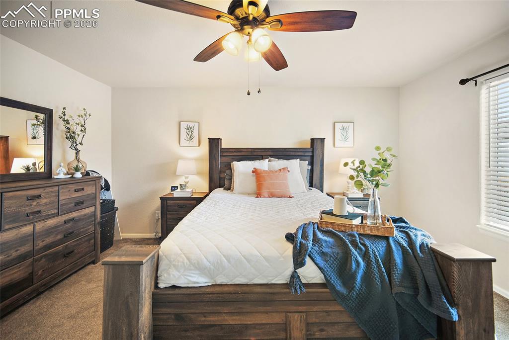 Image 14 of 43: Carpeted room featuring a ceiling fan with integrated lighting, a window wi