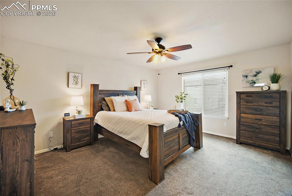 Image 15 of 43: Carpeted bedroom with a ceiling fan light fixture