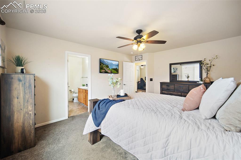 Image 16 of 43: Expansive bedroom featuring neutral wall tones and dark wood-finish cabinet