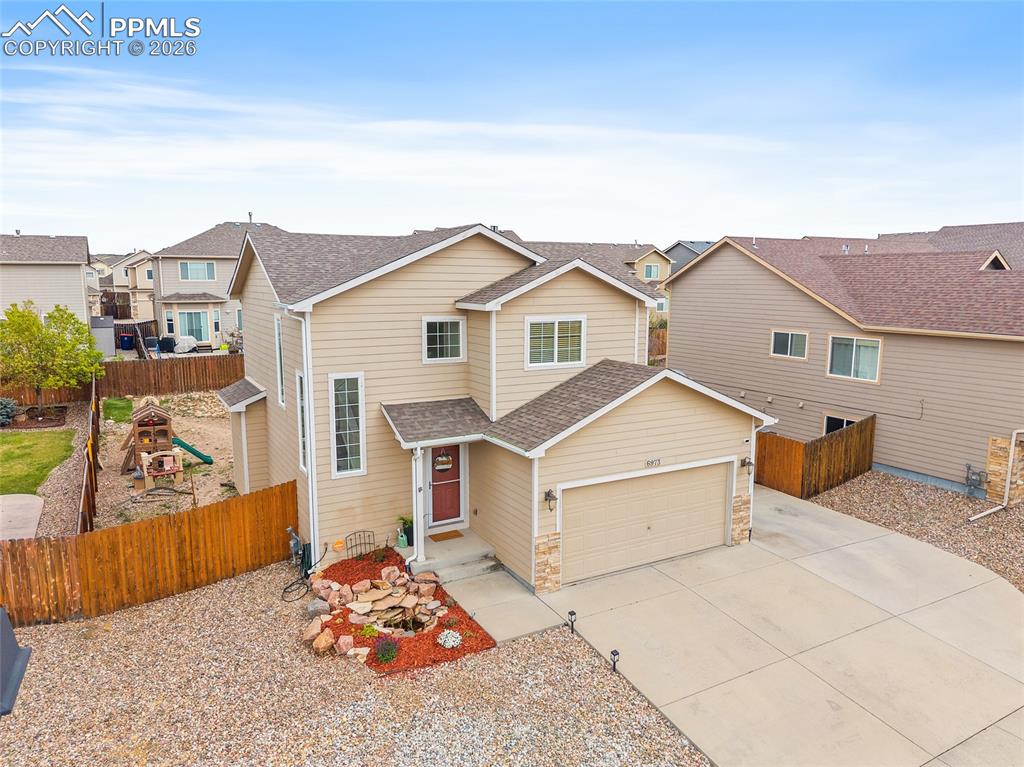 Image 2 of 43: Two-story residence featuring light beige siding and a two-car garage