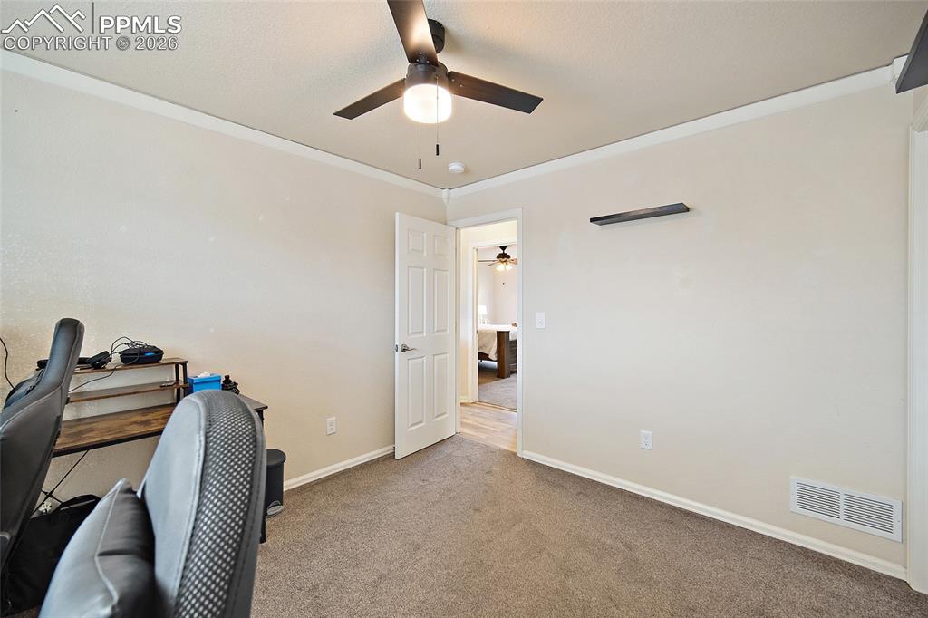 Image 23 of 43: Carpeted room featuring a ceiling fan with integrated lighting, crown moldi