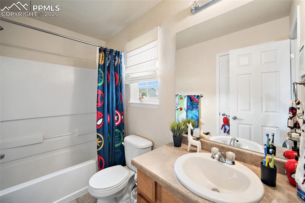 Image 25 of 43: Full bathroom featuring a white tub-shower combination, a toilet, and a van