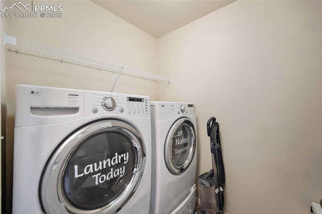 Image 26 of 43: Dedicated laundry area featuring a white wire shelf for storage