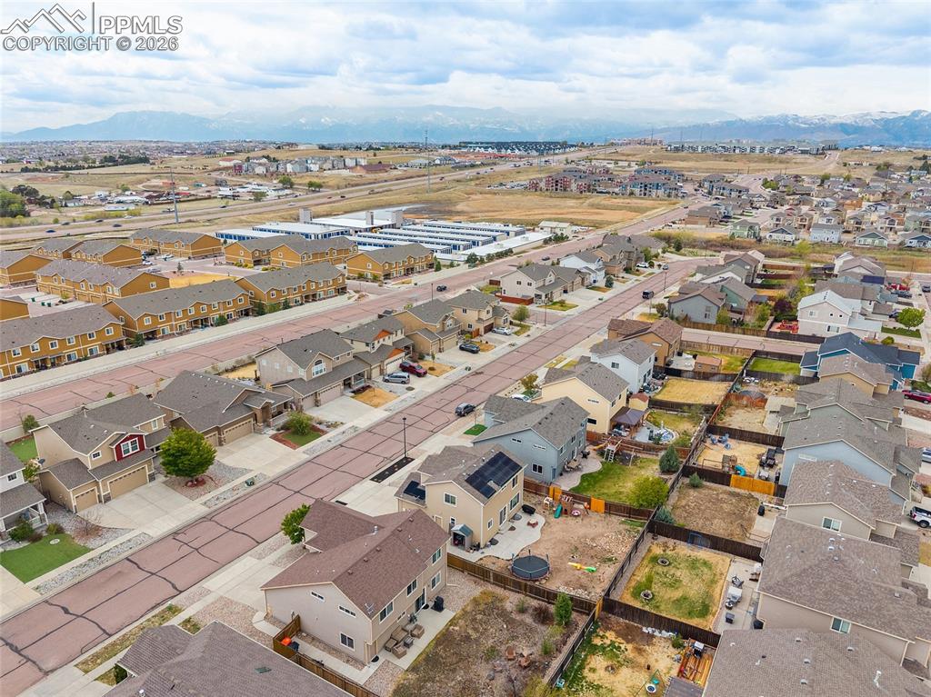 Image 32 of 43: Aerial overview of a residential neighborhood with distant mountains