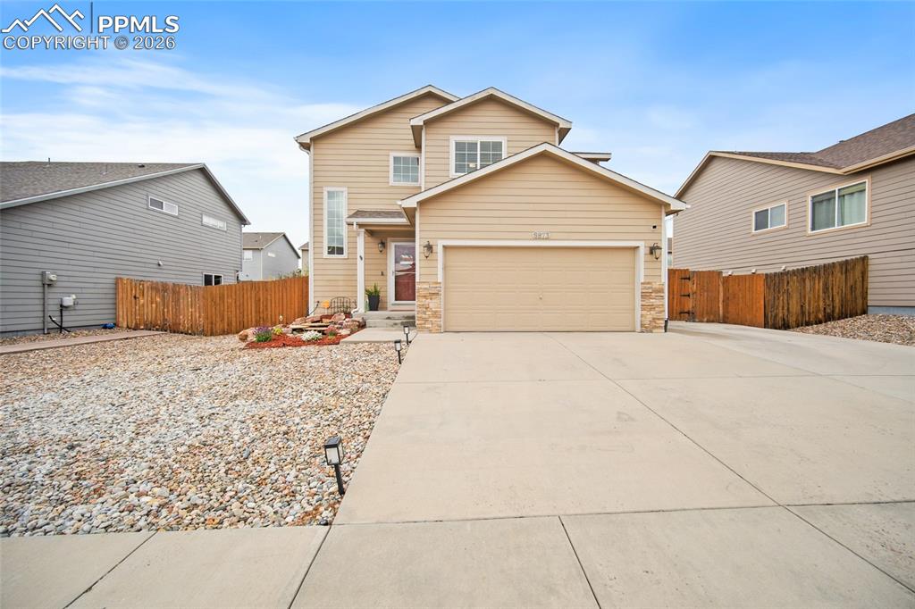 Image 41 of 43: Two-story residence featuring light beige siding, an attached two-car garag