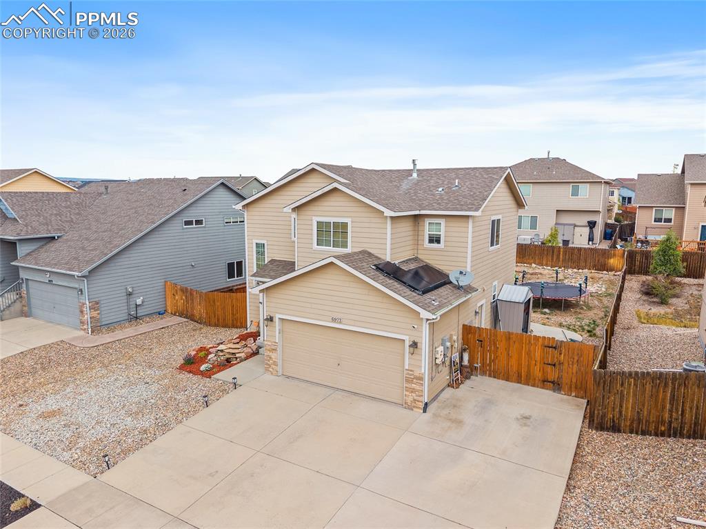 Image 42 of 43: Two-story residence featuring light-toned siding and stone accents