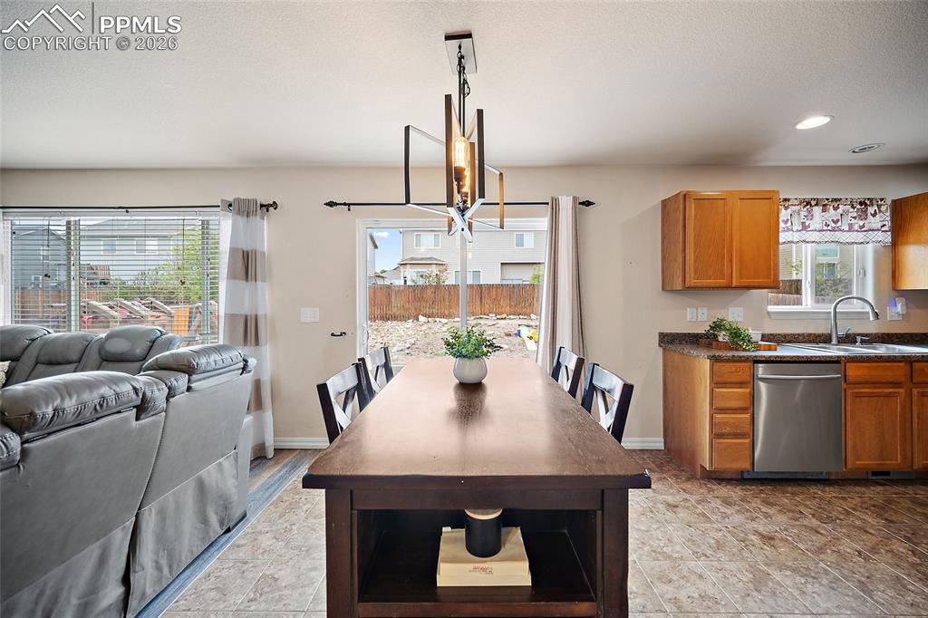 Image 6 of 43: Open-concept living space featuring a dining area with a contemporary chand