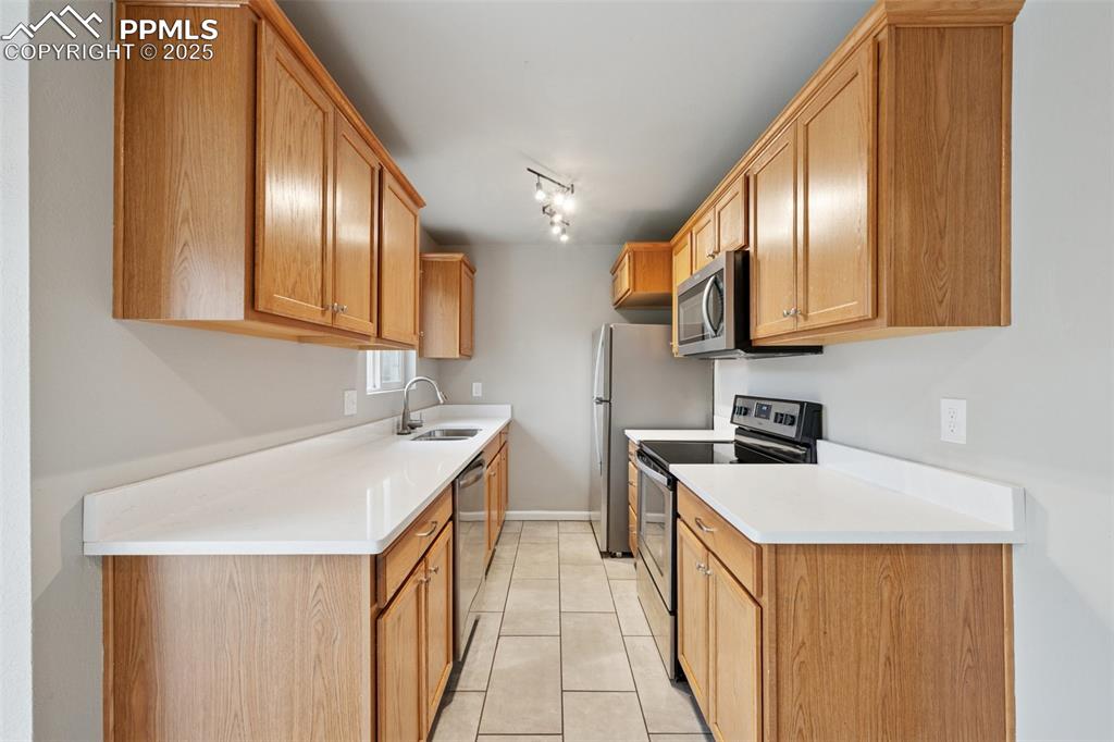 Image 11 of 37: Kitchen featuring appliances with stainless steel finishes, light tile patt