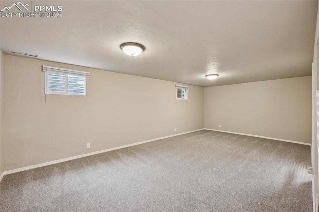 Image 19 of 37: Basement with plenty of natural light, light colored carpet, and a textured