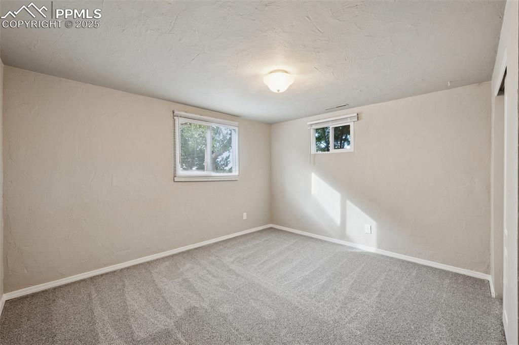 Image 24 of 37: Carpeted empty room featuring a textured ceiling and a textured wall