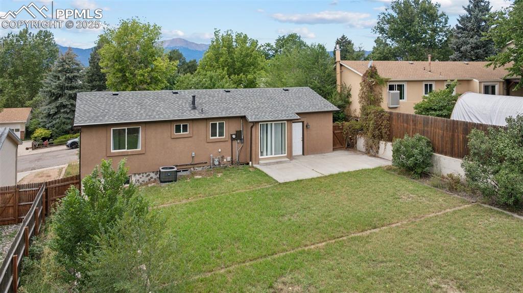 Image 31 of 37: Back of house with a patio, a shingled roof, a fenced backyard, stucco sidi