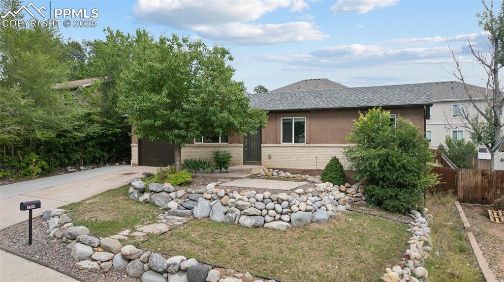 Image 33 of 37: View of front of home with roof with shingles, brick siding, and driveway