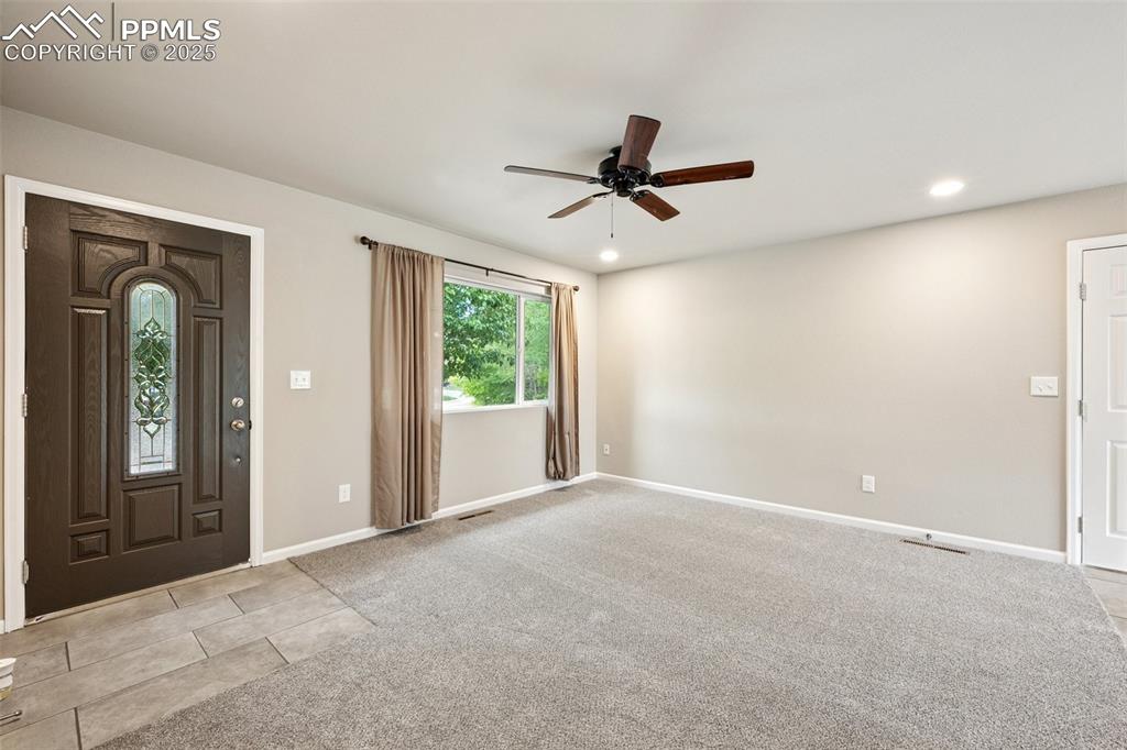 Image 8 of 37: Entrance foyer with light colored carpet, recessed lighting, light tile pat