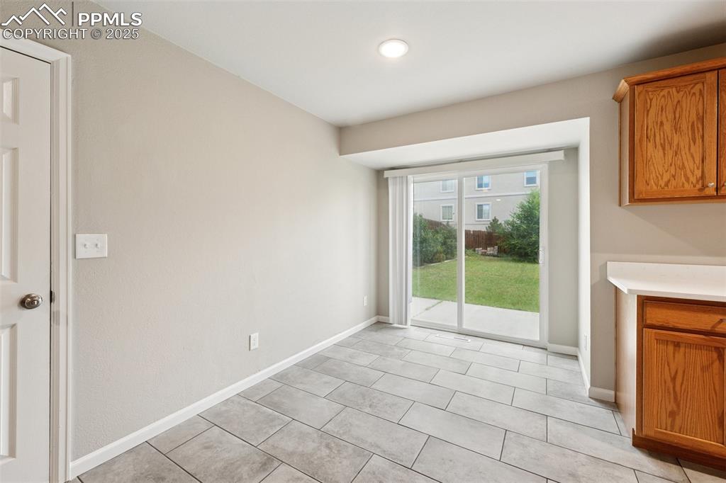 Image 9 of 37: Unfurnished dining area with baseboards and light tile patterned flooring