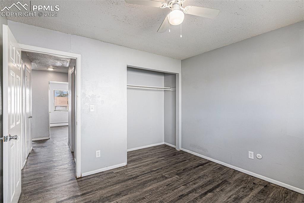 Image 13 of 18: Unfurnished bedroom featuring a textured ceiling, wood finished floors, a c