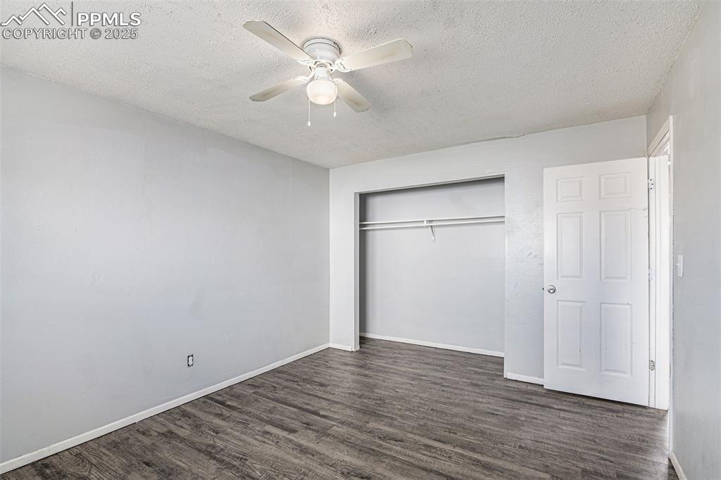 Image 16 of 18: Unfurnished bedroom with a textured ceiling, wood finished floors, a closet