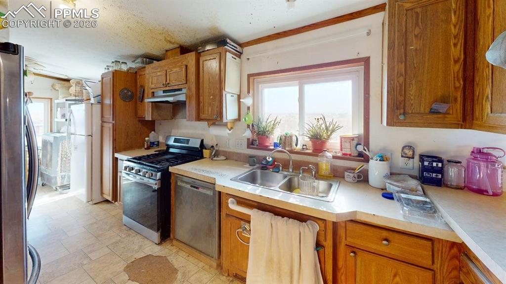 Image 14 of 31: Kitchen featuring wood finish cabinetry, stainless steel appliances, and li
