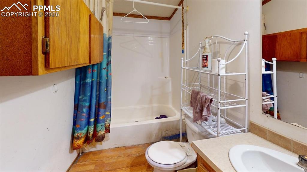 Image 26 of 31: Bathroom with shower / tub combo with curtain and vanity