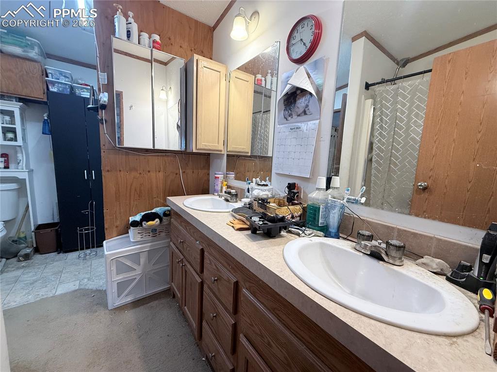 Image 28 of 31: Bathroom with double vanity and curtained shower