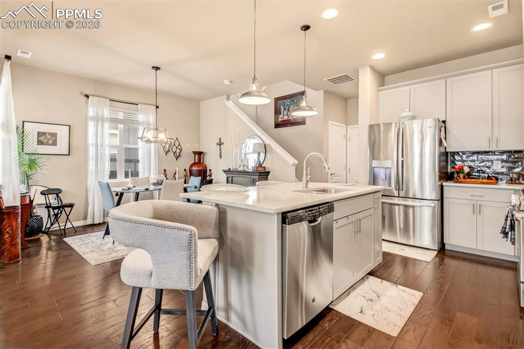 Image 10 of 32: Open concept kitchen with island, breakfast bar, stainless steel appliances