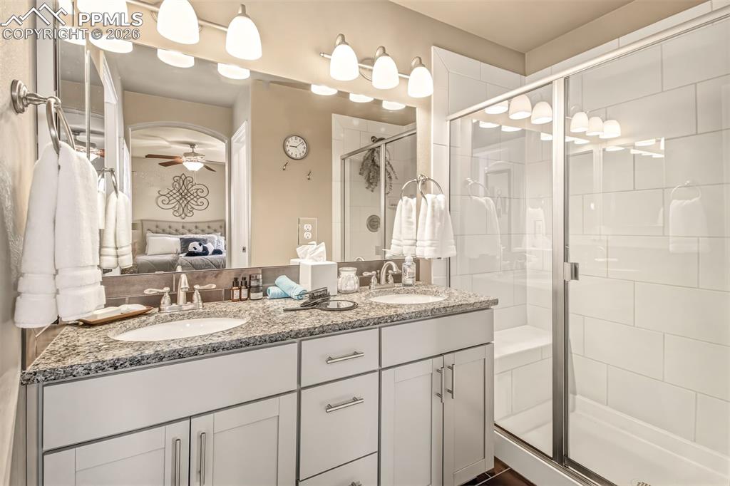 Image 18 of 32: En suite primary bathroom with dual vanity with a granite countertop, walk 