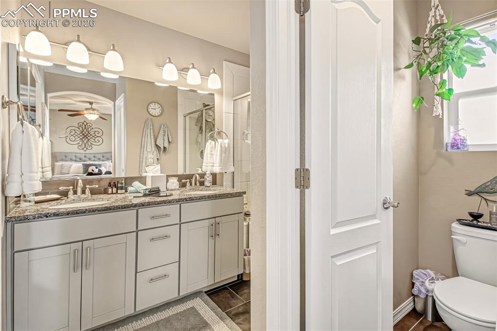 Image 19 of 32: En suite primary bathroom with dual vanity with a granite countertop, walk 