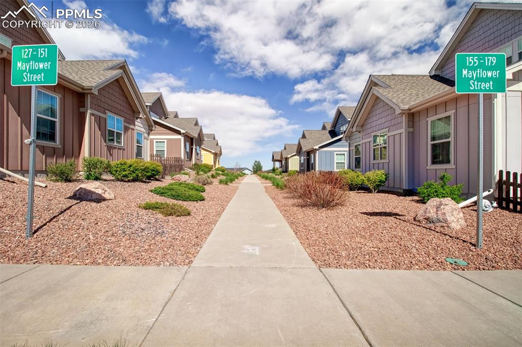 Image 28 of 32: Walk way to the townhome. Juts look at that amazing landscaping!