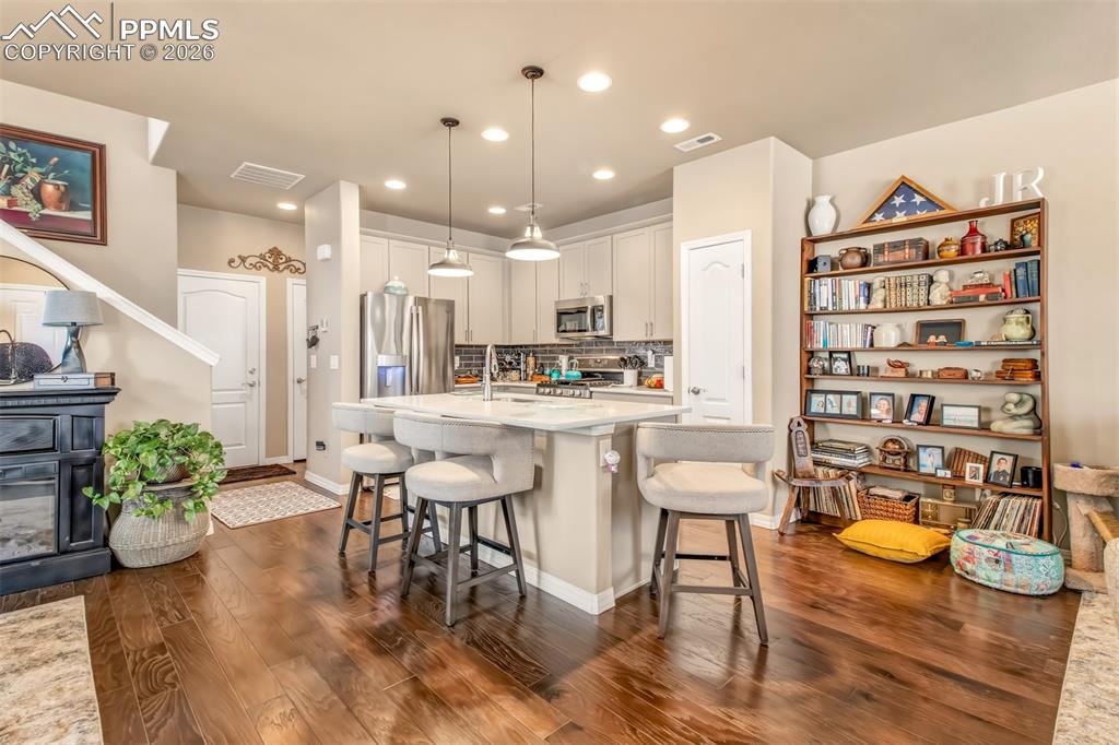 Image 9 of 32: Open concept kitchen with island, breakfast bar, stainless steel appliances