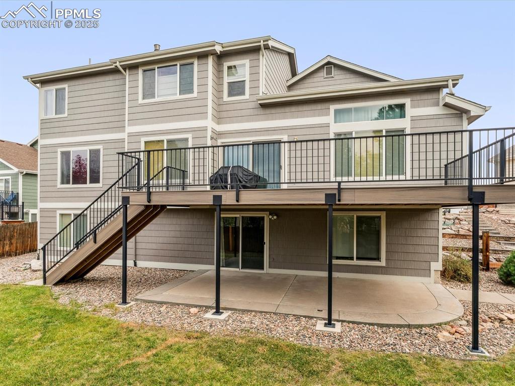 Image 10 of 45: Back of house featuring stairway, a patio, a yard, and a deck