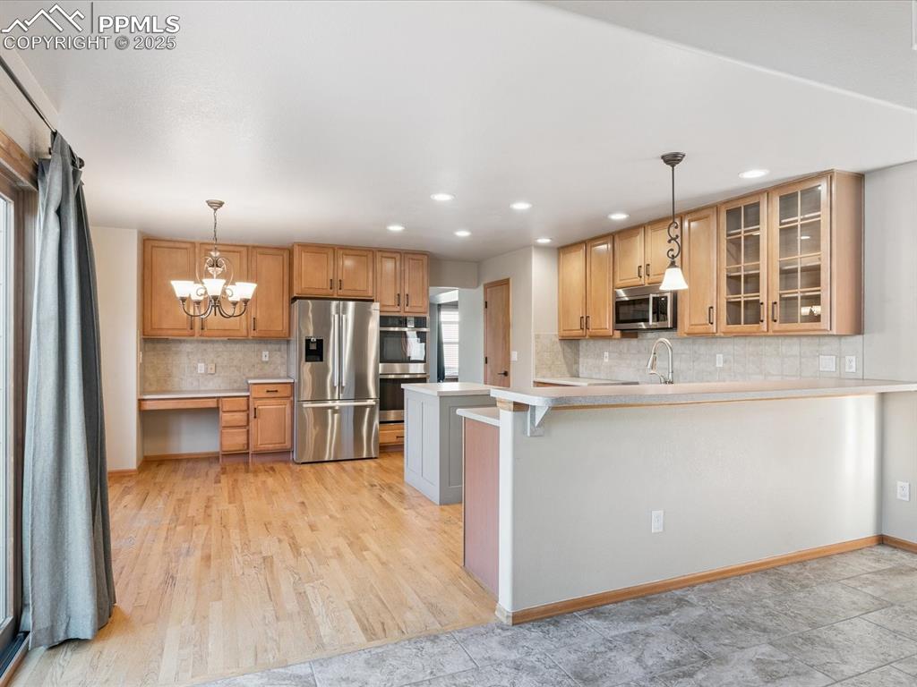 Image 21 of 45: Kitchen with light countertops, appliances with stainless steel finishes, a