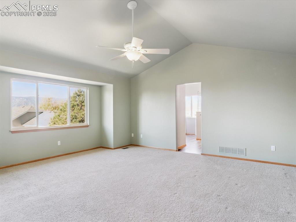 Image 29 of 45: Empty room featuring vaulted ceiling, light colored carpet, and a ceiling f