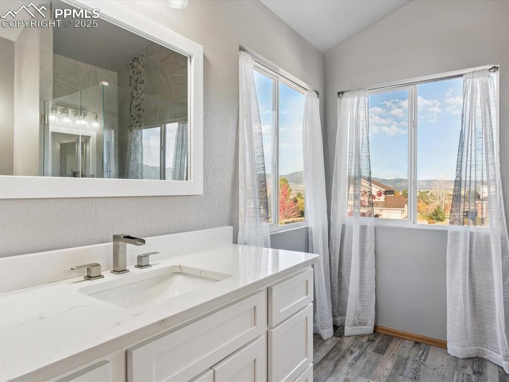 Image 30 of 45: Bathroom featuring vanity, a textured wall, light wood-style flooring, and 