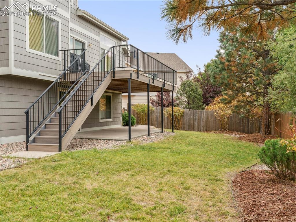 Image 5 of 45: Fenced backyard with a patio, stairs, and a wooden deck