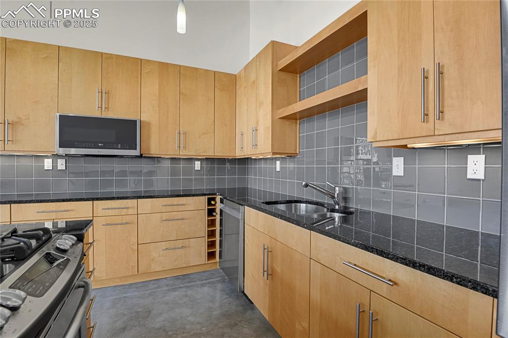 Image 9 of 42: Glass tile backsplash and open shelving above sink