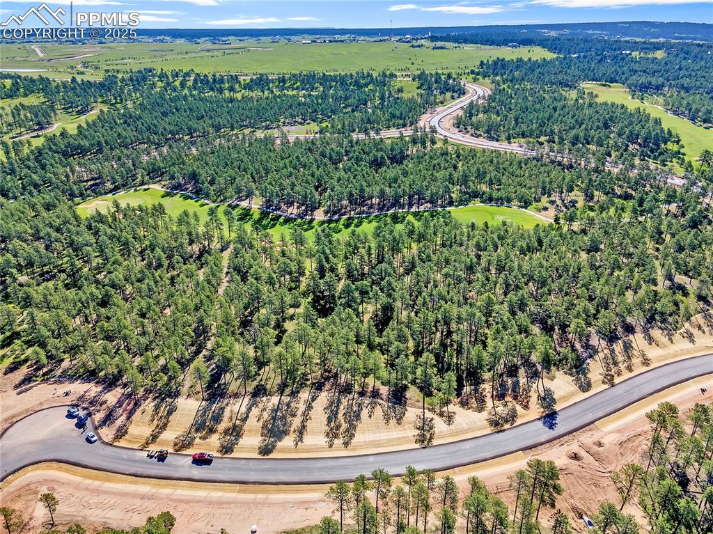 Image 5 of 9: Aerial view of property and surrounding area featuring a forest
