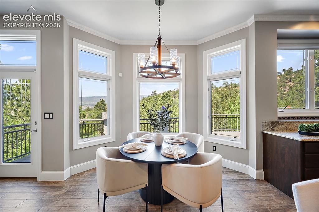 Image 13 of 50: Dining area featuring wood-finish flooring and a bay window design