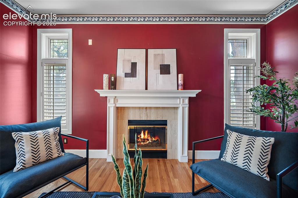 Image 16 of 50: Living area featuring a fireplace with a white mantel and stone surround, w