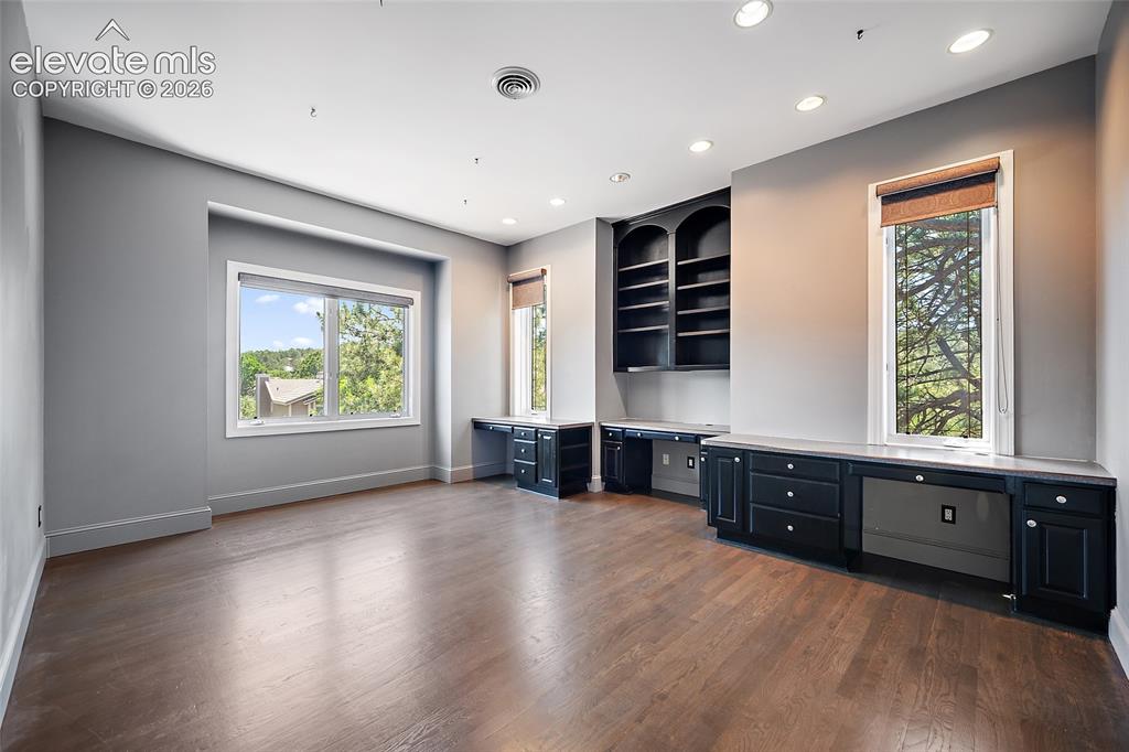 Image 25 of 50: Spacious room featuring wood-finish flooring, recessed lighting, and multip