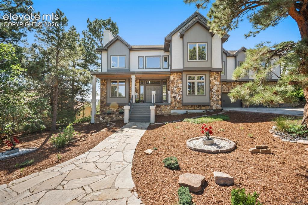Image 3 of 50: Stately multi-story residence featuring a stone and stucco exterior, promin