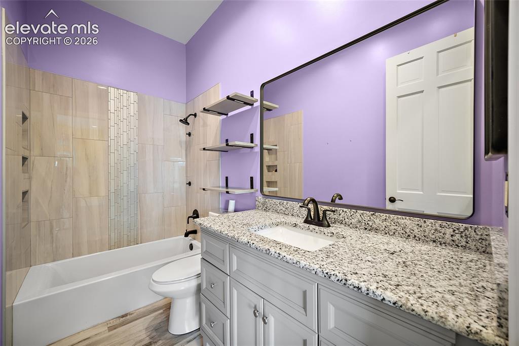 Image 30 of 50: Bathroom featuring a built-in tub with tile surround, a built-in toilet, an