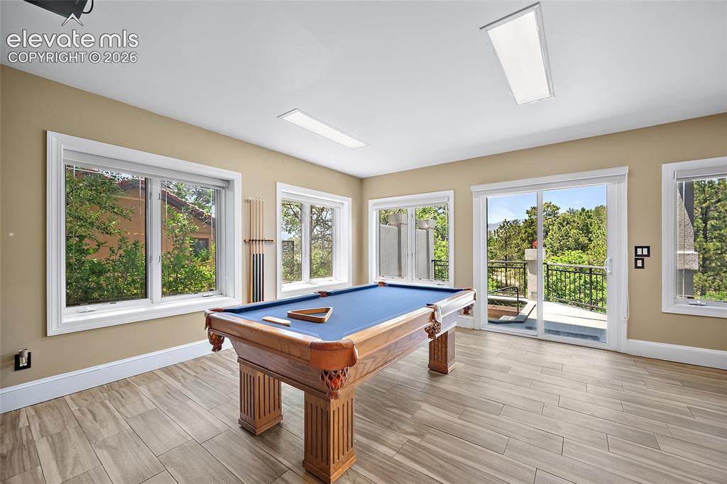 Image 31 of 50: Spacious room featuring wood-finish flooring, recessed lighting, and multip