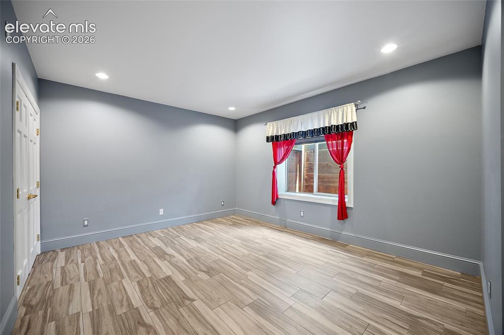 Image 36 of 50: Spacious room featuring light wood-finish flooring, recessed lighting, a wh