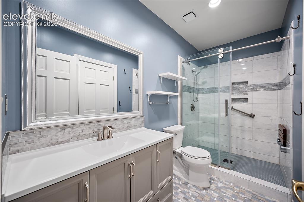 Image 37 of 50: Full bathroom featuring a single vanity with a white countertop and gray ca