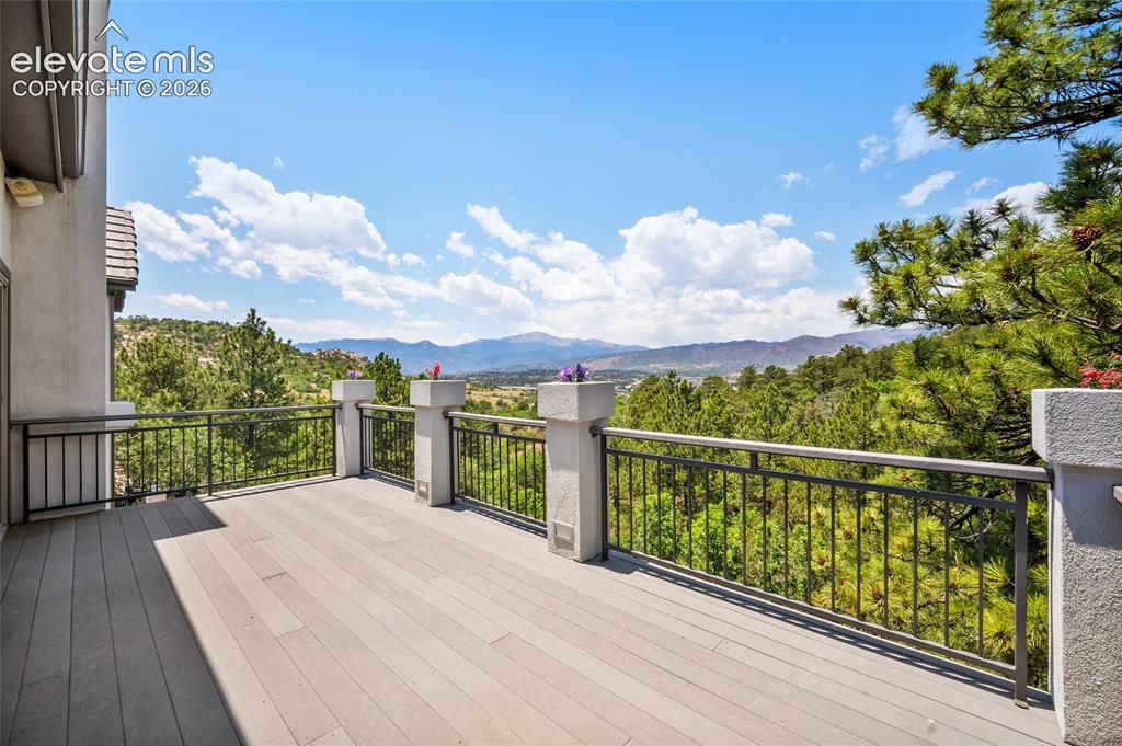Image 39 of 50: Expansive outdoor deck featuring wood-finish decking and dark metal railing