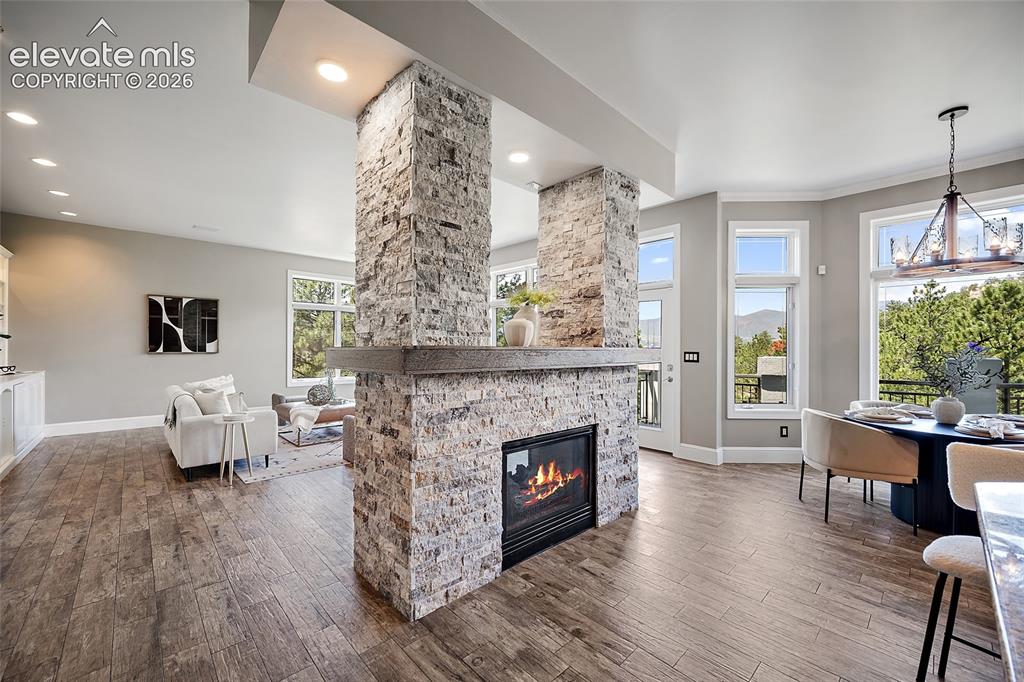 Image 6 of 50: Central stone-clad fireplace with a substantial wood mantel
