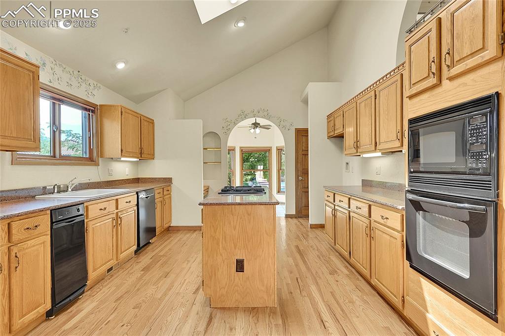 Image 11 of 30: Kitchen featuring black appliances, light wood finished floors, healthy amo