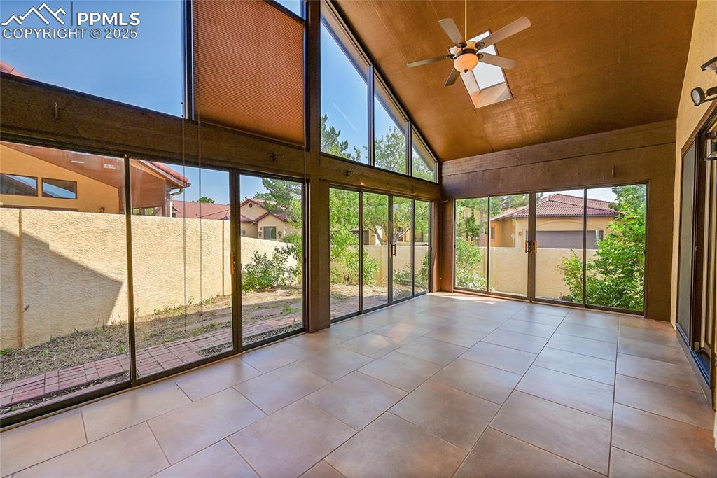 Image 14 of 30: Unfurnished sunroom with vaulted ceiling and a skylight